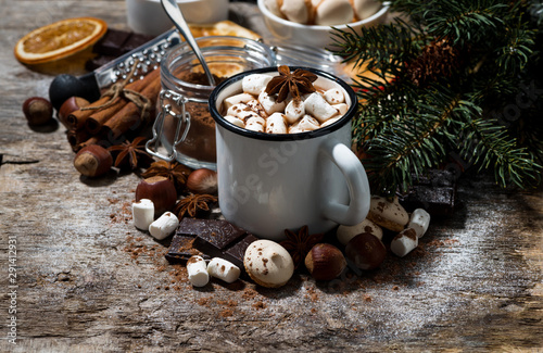 cup of hot chocolate with marshmallows and sweets on wooden background