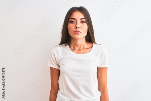 Young beautiful woman wearing casual t-shirt standing over isolated white background Relaxed with serious expression on face. Simple and natural looking at the camera. © Krakenimages.com