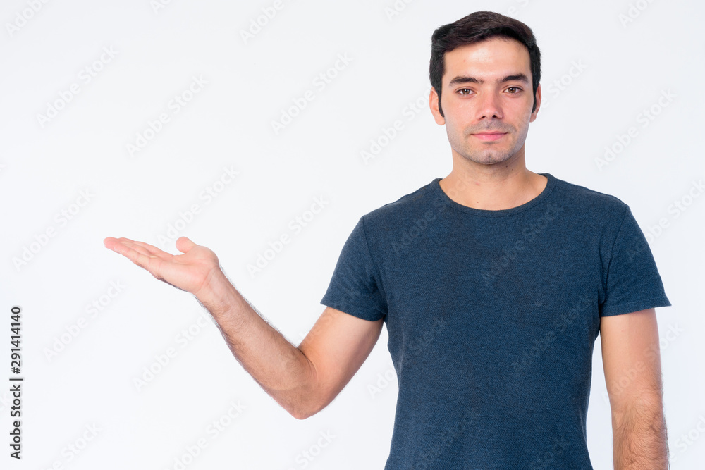 Portrait of young handsome Persian man showing something Portrait of young handsome Persian man showing something