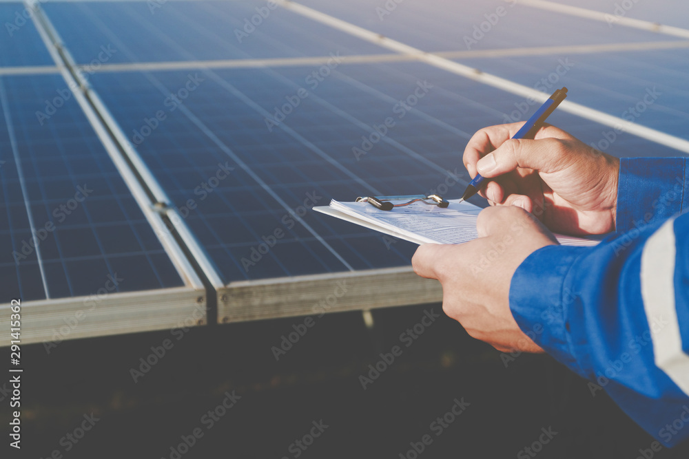 custom made wallpaper toronto digitalindustrial concept; engineer in blue uniform working on repairing generating power of solar power plant