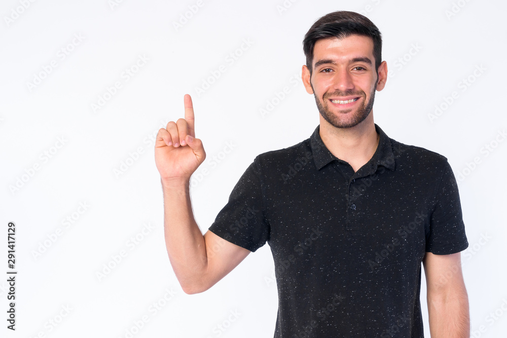 Portrait of happy young bearded Persian man pointing up Portrait of happy young bearded Persian man pointing up