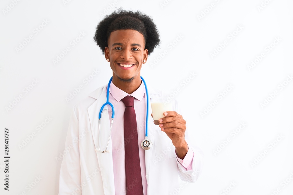 Young african american doctor man drinking glass of milk over isolated white background with a happy face standing and smiling with a confident smile showing teeth Young african american doctor man drinking glass of milk over isolated white background with a happy face standing and smiling with a confident smile showing teeth