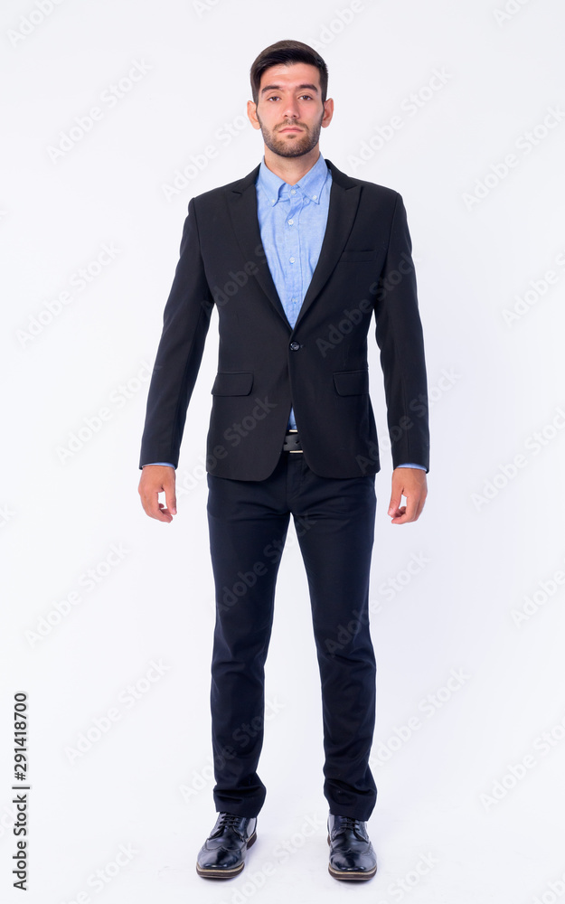 Full body shot of young bearded Persian businessman in suit Full body shot of young bearded Persian businessman in suit