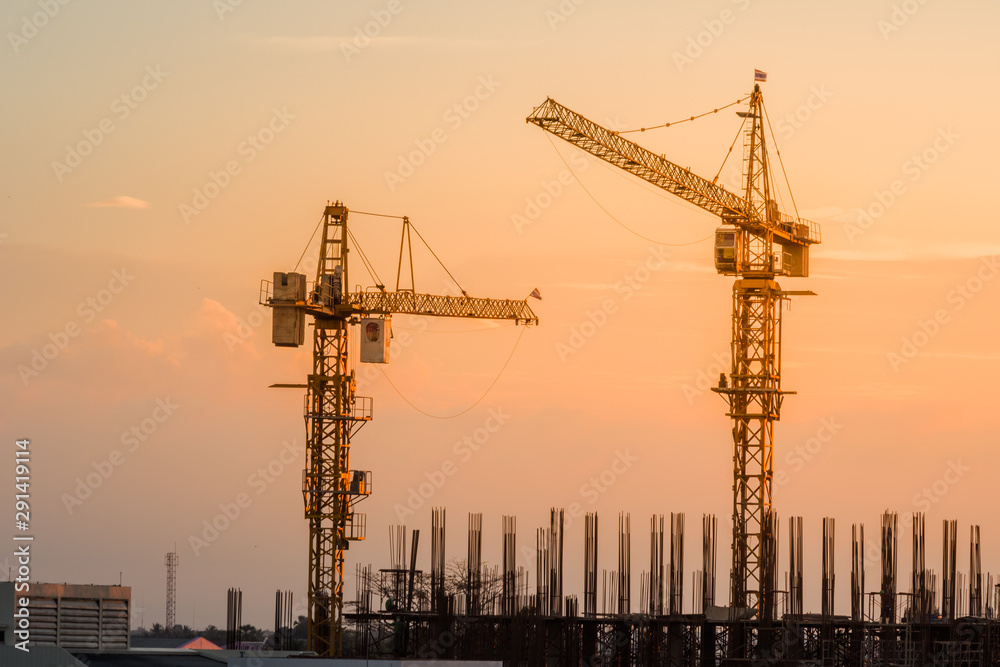 construction canes over building site on sunset sky in the evening