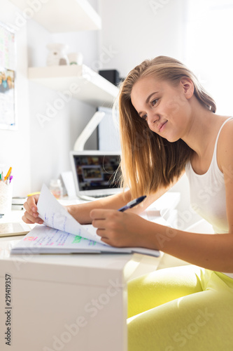 Teenage girl studing for school on a sunny Sunday morning