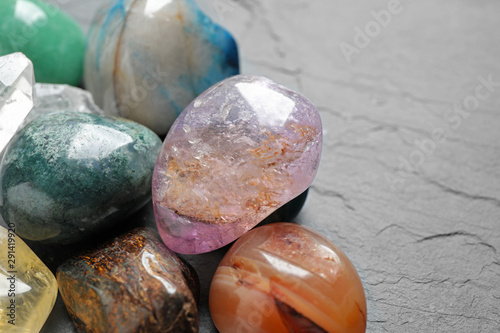 Different beautiful gemstones on grey background, closeup photo