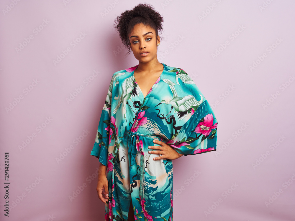 Young beautiful african american woman standing wearing elegant colorful caftan Young beautiful african american woman standing wearing elegant colorful caftan