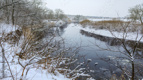 quiet winter outdoor scene, river with snowbound forest at the coast