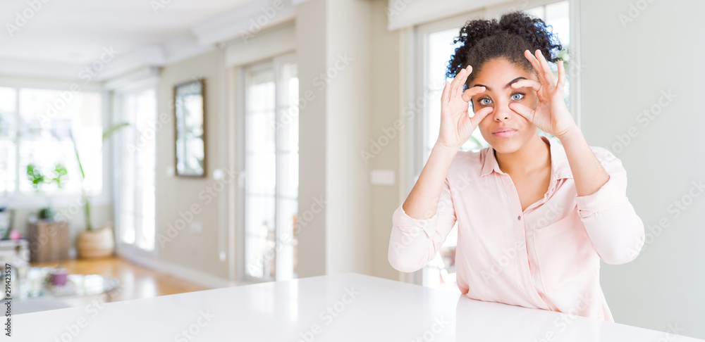 Wide angle of beautiful african american woman with afro hair Trying to open eyes with fingers, sleepy and tired for morning fatigue Wide angle of beautiful african american woman with afro hair Trying to open eyes with fingers, sleepy and tired for morning fatigue