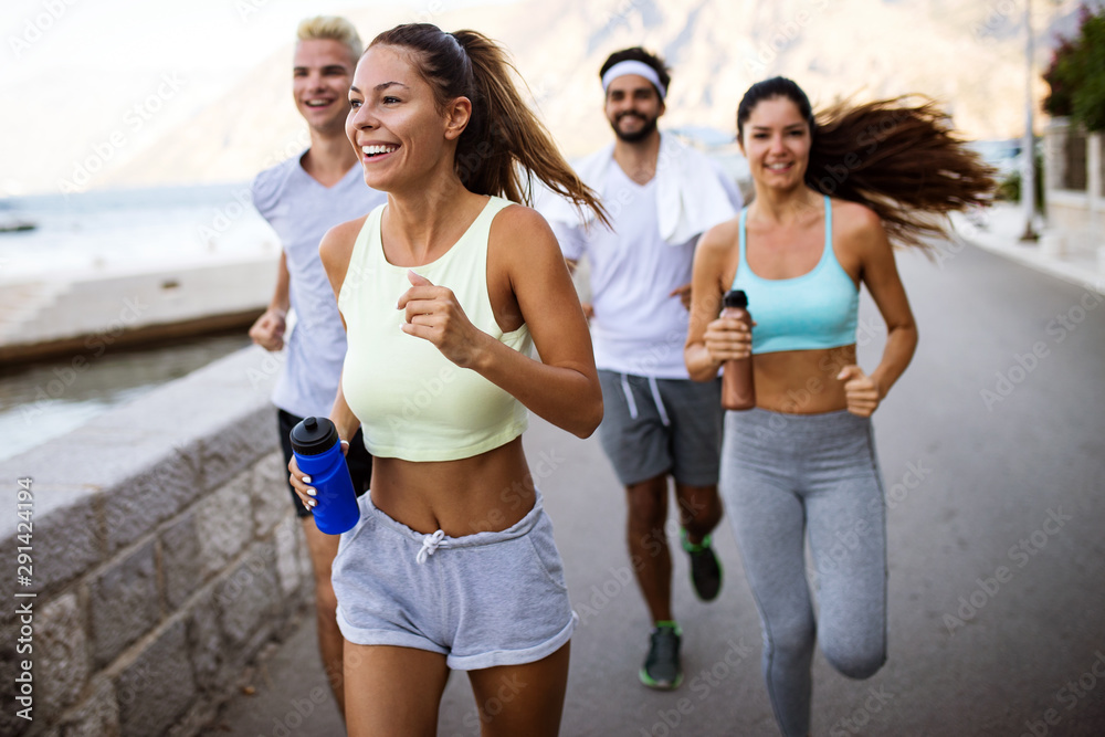 Obraz premium Group of young people friends running outdoors at seaside