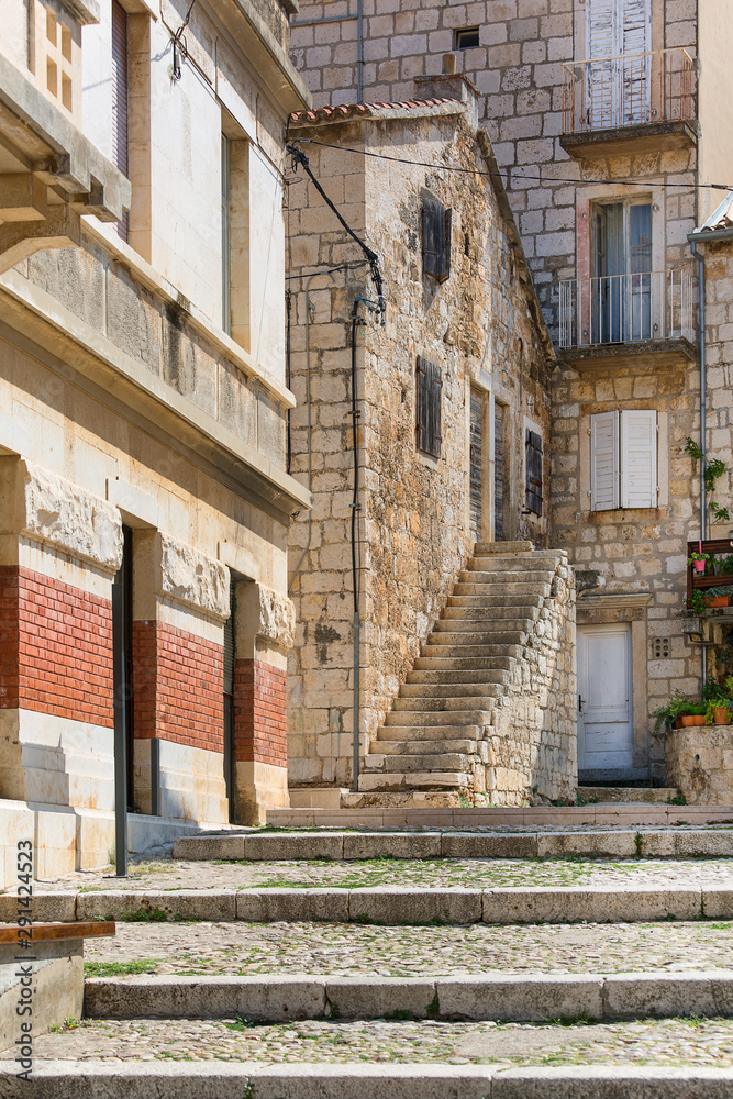 Old stone houses in a charming alley, typical Mediterranean architecture, island Vis, Komiza, Croatia