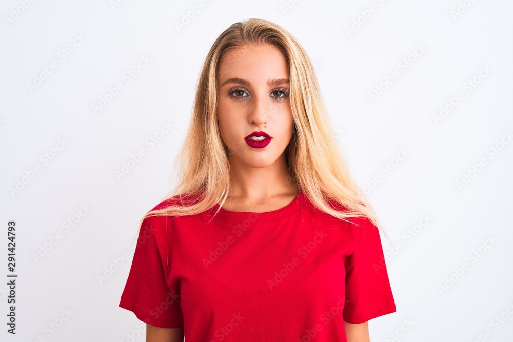 Young beautiful woman wearing red casual t-shirt standing over isolated white background with serious expression on face. Simple and natural looking at the camera. Young beautiful woman wearing red casual t-shirt standing over isolated white background with serious expression on face. Simple and natural looking at the camera.