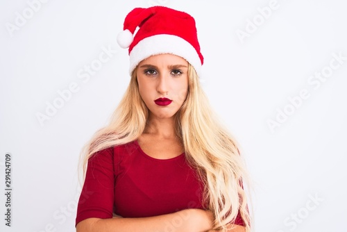 Young beautiful woman wearing Christmas Santa hat over isolated white background skeptic and nervous  disapproving expression on face with crossed arms. Negative person.