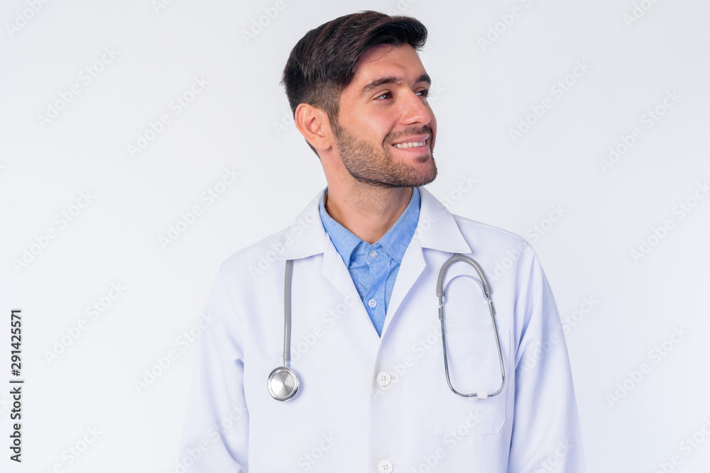 Face of happy young bearded Persian man doctor thinking Face of happy young bearded Persian man doctor thinking
