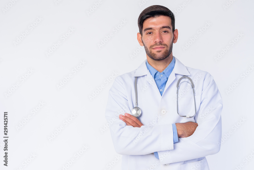 Portrait of young bearded Persian man doctor with arms crossed