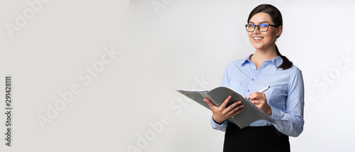 Businesswoman Taking Notes Holding Folder Looking At Camera, Panorama photo