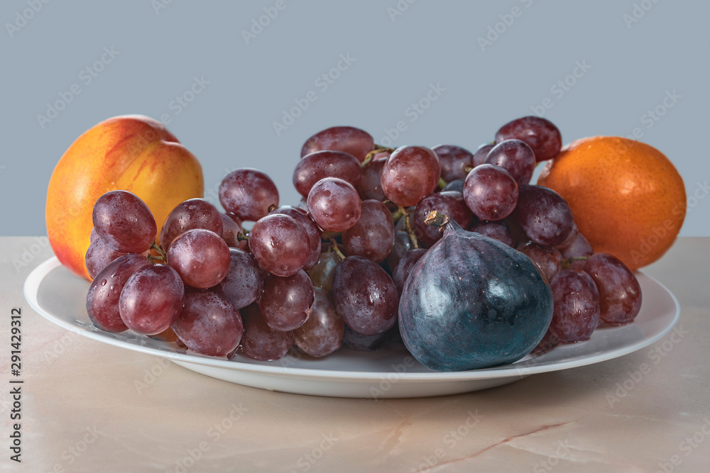red grape berries and fresh fruits in a ceramic plate on a wooden background red grape berries and fresh fruits in a ceramic plate on a wooden background