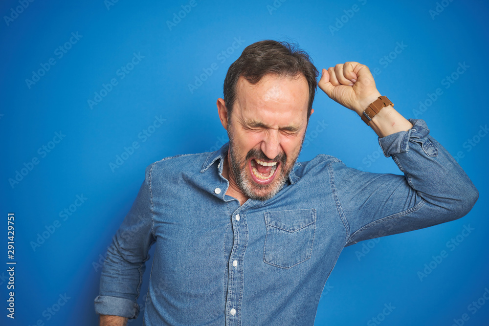 Handsome middle age senior man with grey hair over isolated blue background Dancing happy and cheerful, smiling moving casual and confident listening to music Handsome middle age senior man with grey hair over isolated blue background Dancing happy and cheerful, smiling moving casual and confident listening to music
