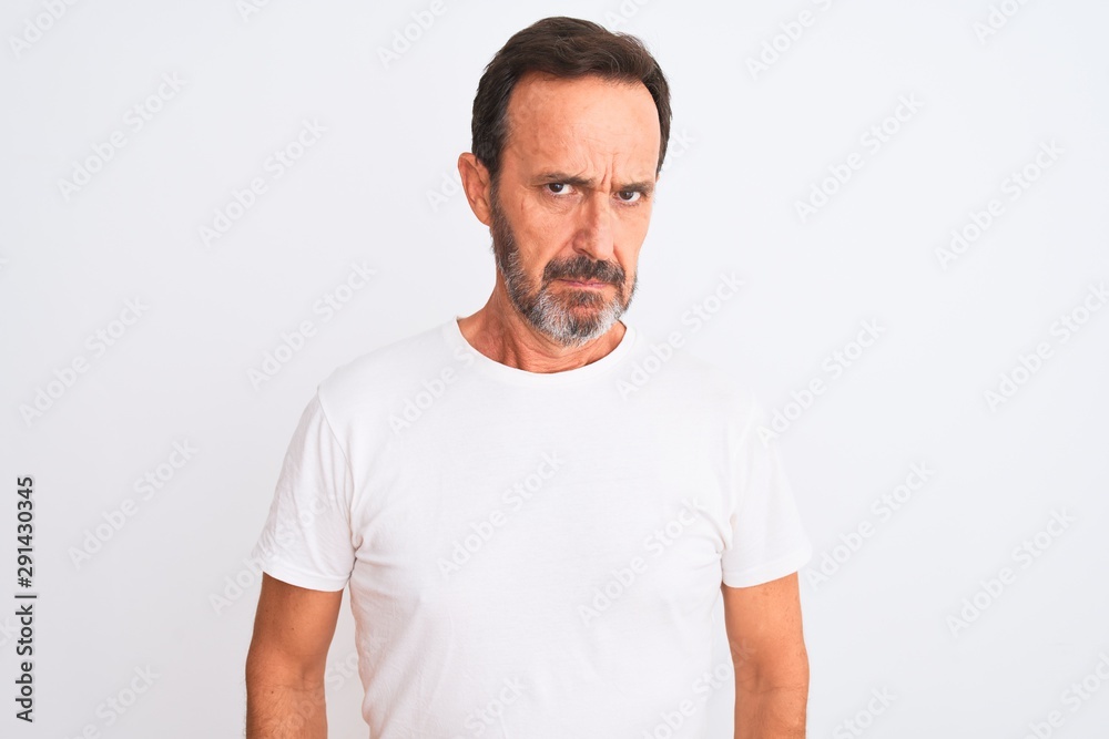 Middle age handsome man wearing casual t-shirt standing over isolated white background skeptic and nervous, frowning upset because of problem. Negative person. Middle age handsome man wearing casual t-shirt standing over isolated white background skeptic and nervous, frowning upset because of problem. Negative person.