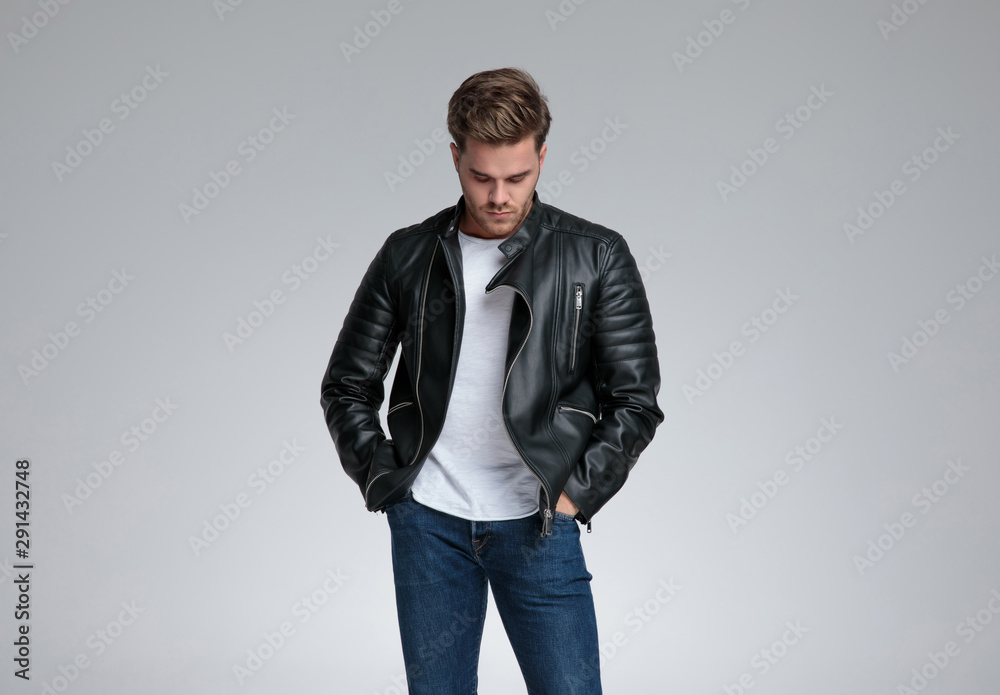 casual man standing with hands in pockets and looking down casual man standing with hands in pockets and looking down