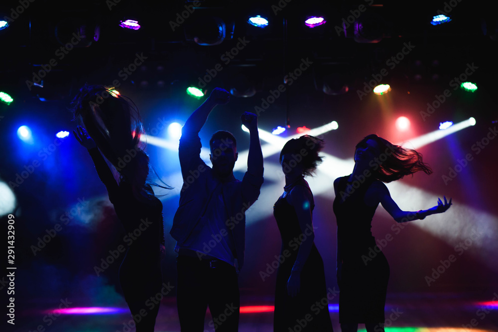 Nightlife and disco concept. Young people are dancing in club.