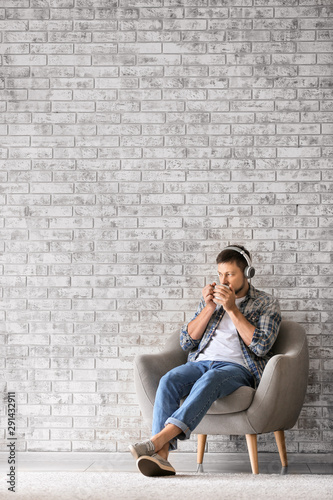 Man with headphones and cup of tea relaxing at home