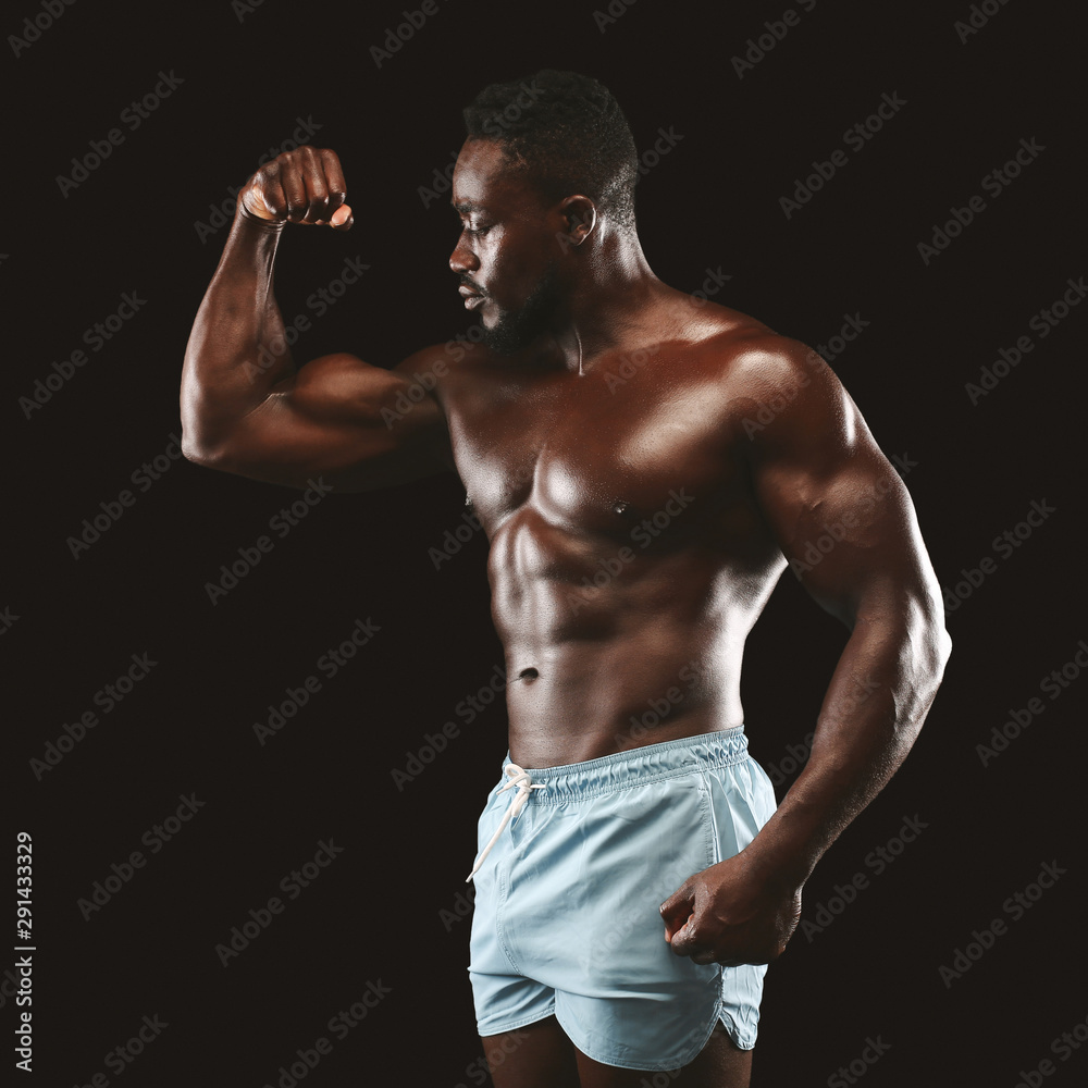 Athletic african guy showing his arm muscles