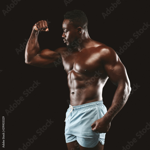 Athletic african guy showing his arm muscles