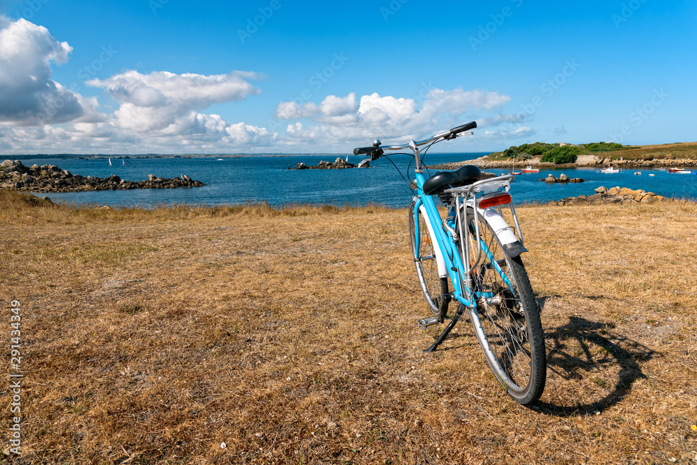 One bicycle parked against the sea in the island of Batz with no people. Summer adventure