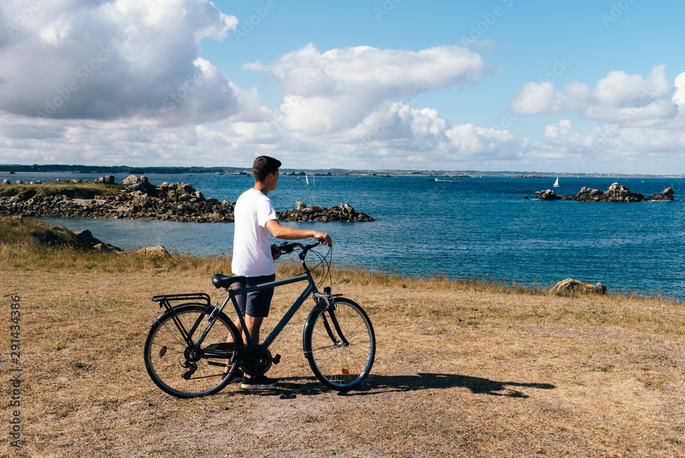 Φωτογραφία Attractive young male riding bicycle in the Island of Batz