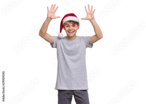 Christmas teen boy in Santa Hat. Cute child in Santa red hat, isolated on white background. Joyful young teenager having fun. Winter holidays. Happy xmas and New Year.