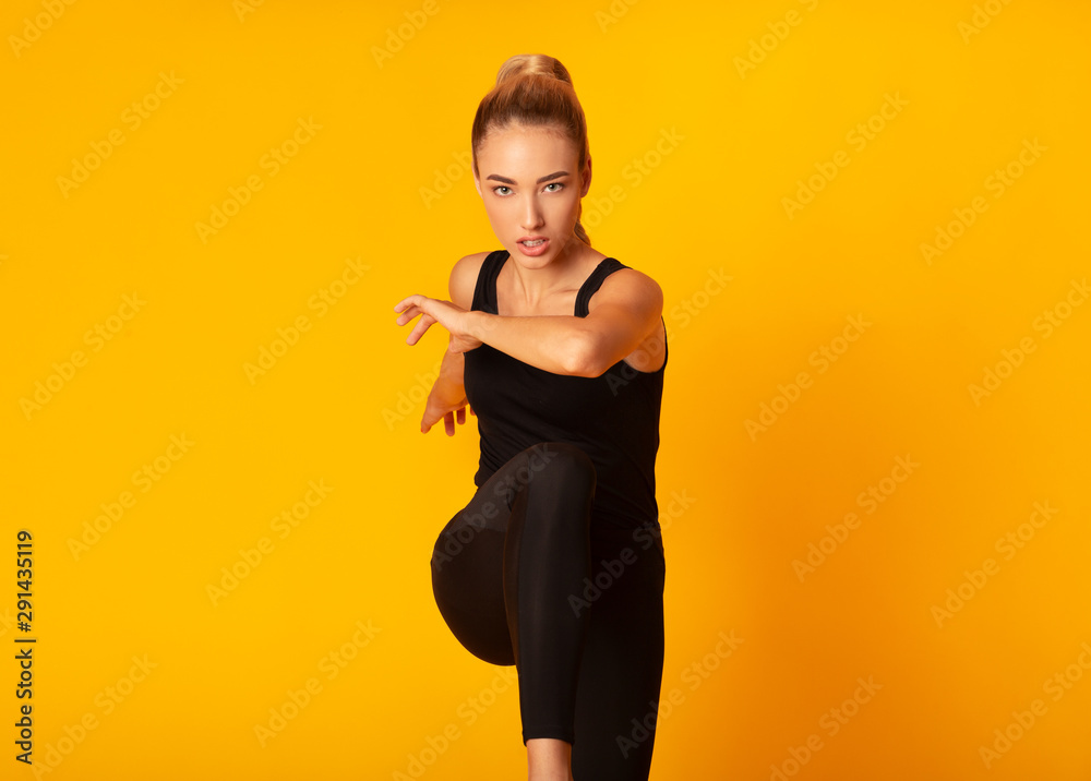 Determined Fitness Woman Jumping On Yellow Studio Background Determined Fitness Woman Jumping On Yellow Studio Background