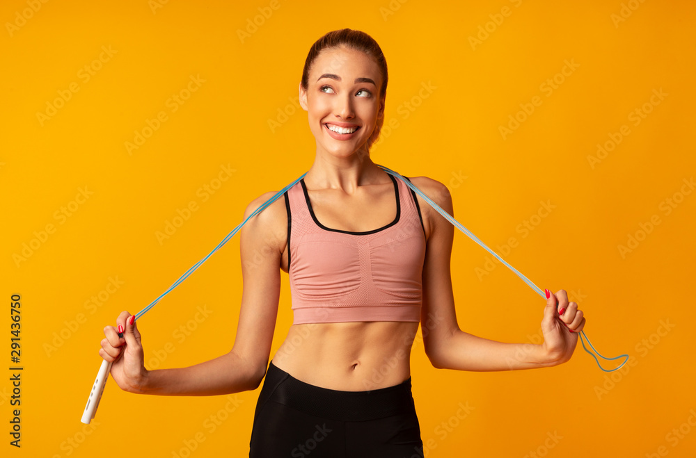 Slim Girl Holding Jump Rope Over Yellow Background Slim Girl Holding Jump Rope Over Yellow Background