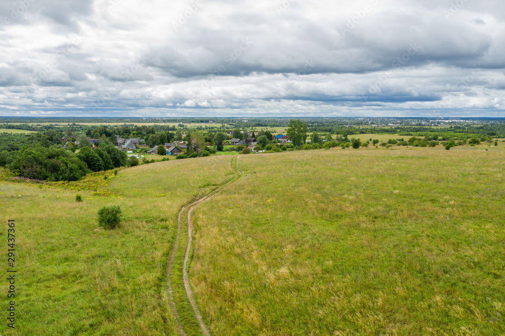 Aerial view on the agricultural field and track towards the village Aerial view on the agricultural field and track towards the village