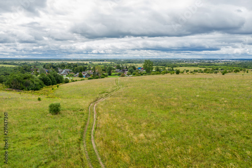 Aerial view on the agricultural field and track towards the village
