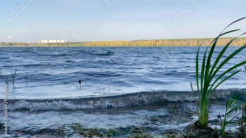 beautiful panorama view of lake beach, trees and mountains and sky, light waves and green grass photo