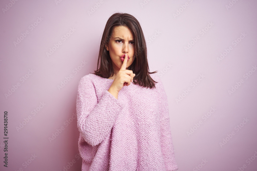 Young beautiful brunette woman wearing a sweater over pink isolated background asking to be quiet with finger on lips. Silence and secret concept. Young beautiful brunette woman wearing a sweater over pink isolated background asking to be quiet with finger on lips. Silence and secret concept.