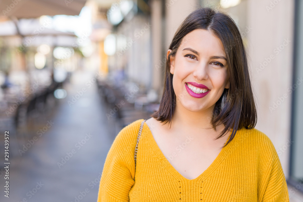 Beautiful young woman smiling cheerful walking on the street on a sunny day, casual pretty girl at the town