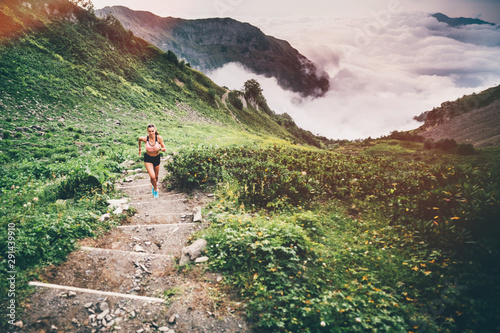 Woman running and jogging in the nature mountain scenery. Concept of healthy lifestyle. Fitness spot girl training in mountain. photo