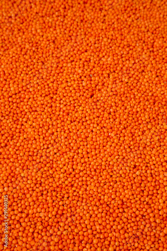 Red lentils texture, side view. Close-up.
