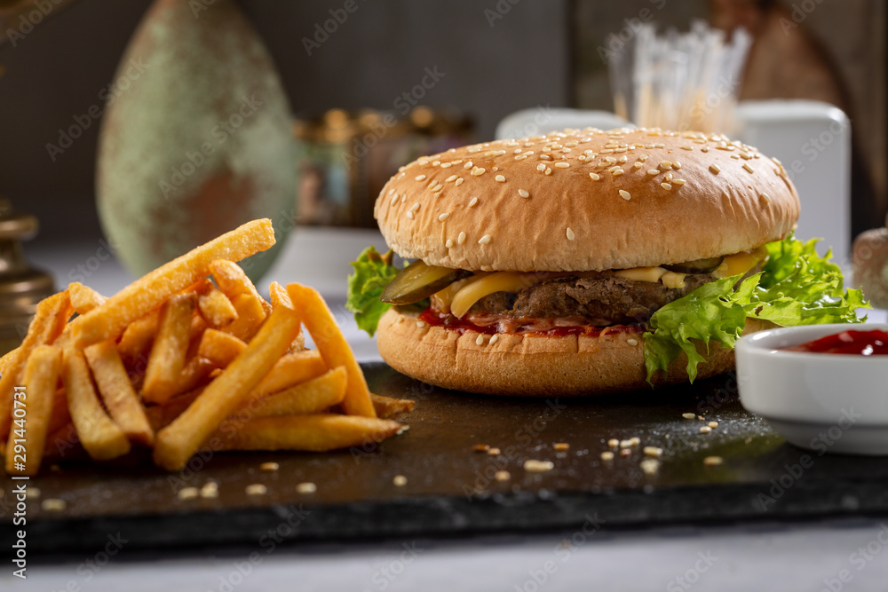 Burger and french fries with sauce on slate Burger and french fries with sauce on slate