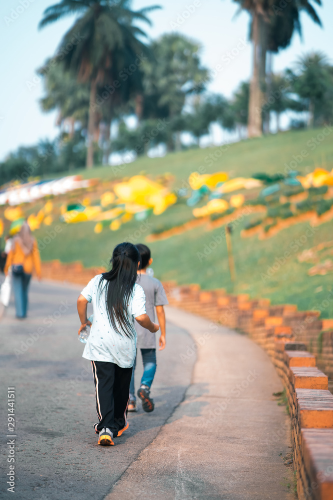 Obraz premium Kids walking in the park. view from behind.
