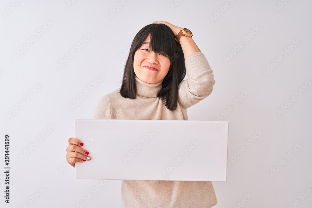 Young beautiful Chinese woman holding banner standing over isolated white background stressed with hand on head, shocked with shame and surprise face, angry and frustrated. Fear and upset for mistake. Young beautiful Chinese woman holding banner standing over isolated white background stressed with hand on head, shocked with shame and surprise face, angry and frustrated. Fear and upset for mistake.