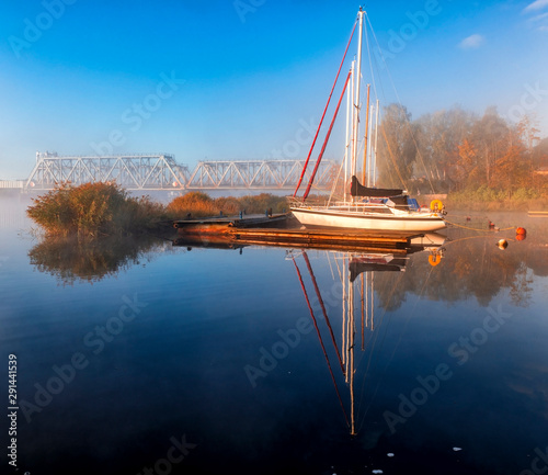 Autumnal mist on a river with sport yachts anchored in harbor,  at dawn, Europe