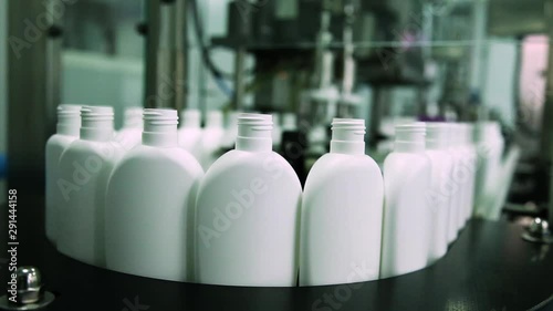 Cosmetics Manufacturing Plant. White Bottles On The Belt Conveyor. Shampoo