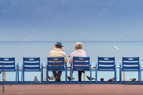 Fototapet Old couple sitting on the bank of the sea