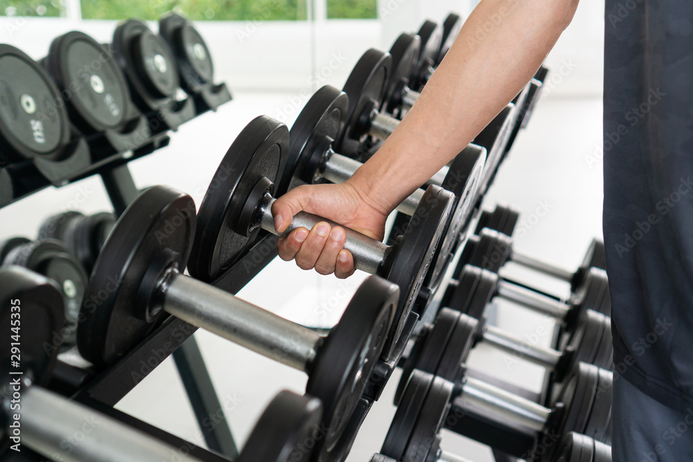 men lifting dumbbell weights getting ready for exercise in fitness. men lifting dumbbell weights getting ready for exercise in fitness.