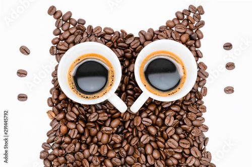 Owl made of roasted coffee beans and two cups. A symbol for night people. Love Coffee. Coffee break. Coffee Time. 