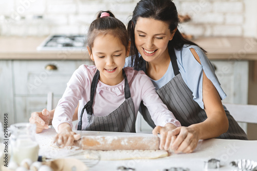 Happy family rolling out the dough for pie together