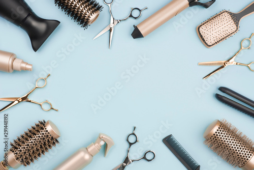 Hair cutting tools and accessories on blue background with space